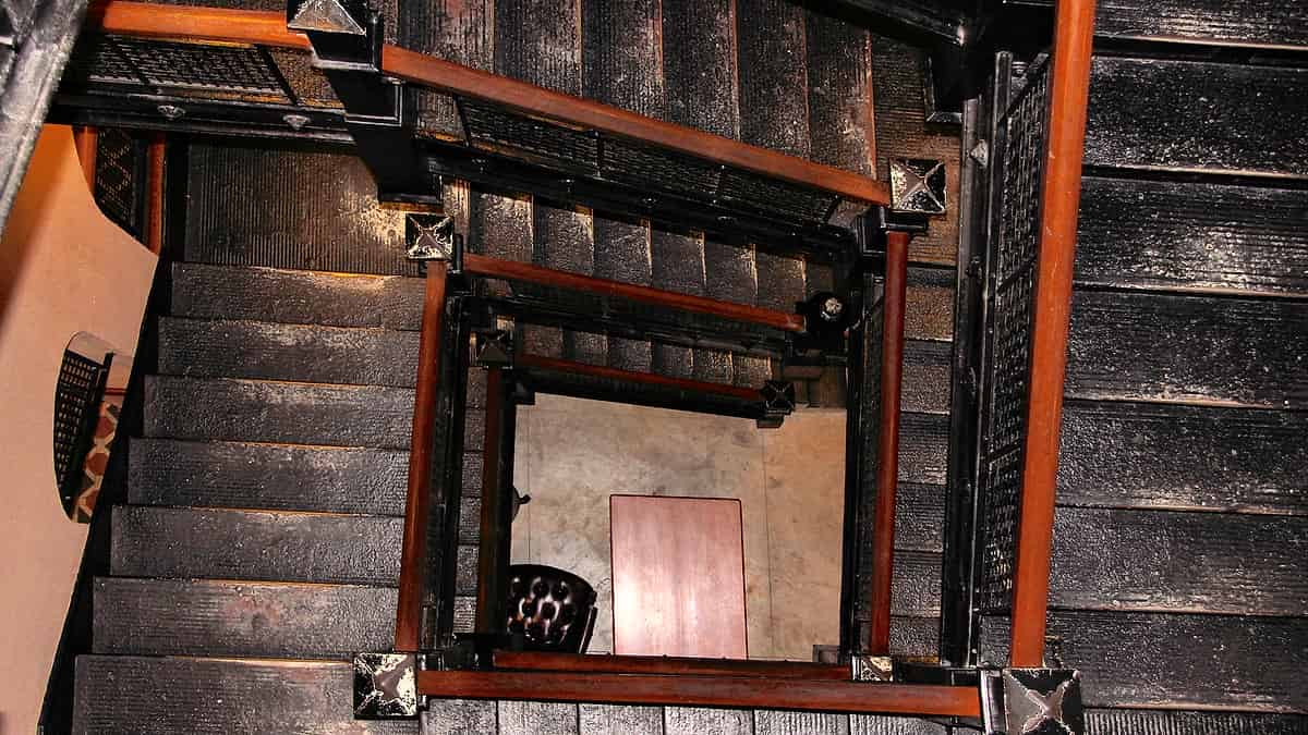 A closed set of double doors at the top of a short flight of stone steps under an overcast sky